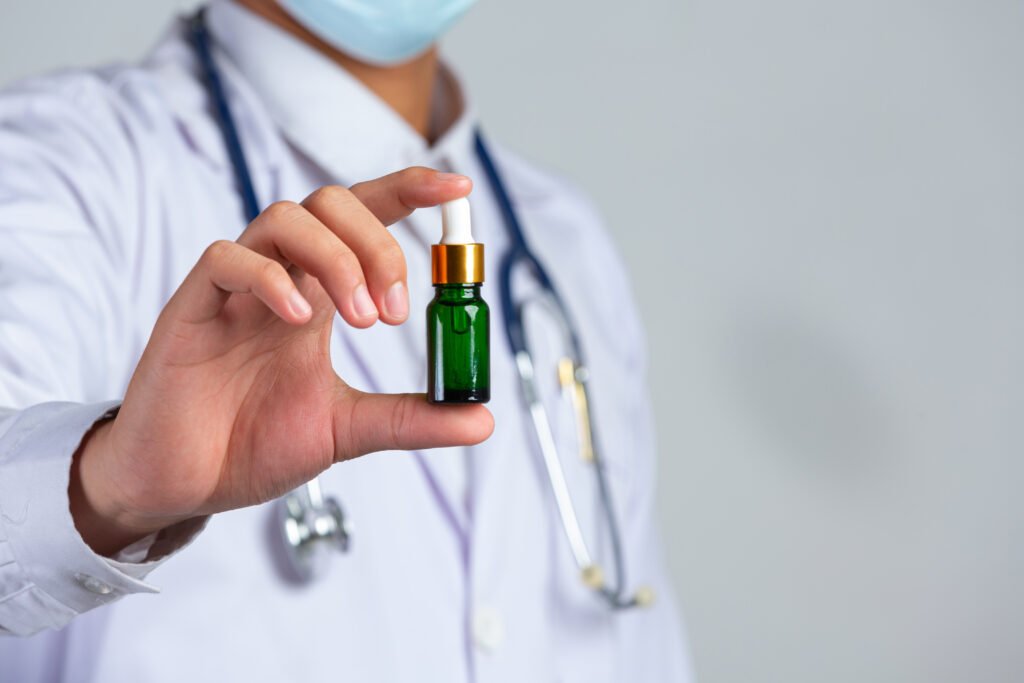 close up picture of medical doctor holding a bottle of cannabis oil on white background.